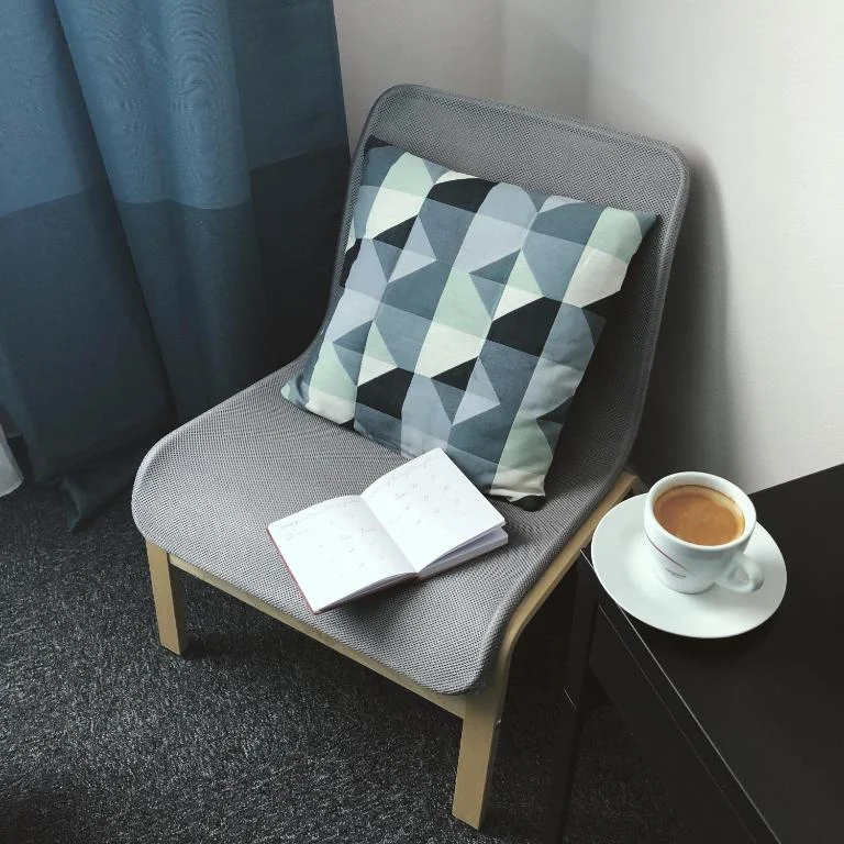 Čítací kútik s kreslom a kávou v hotelovej izbe, Hotel TeleDom Košice