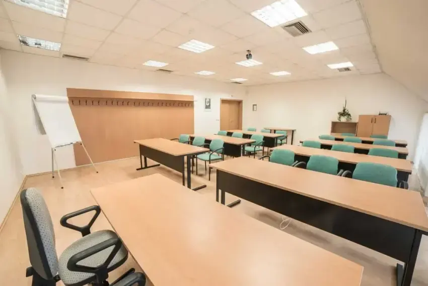 Manažérska učebňa v Hoteli TeleDom Košice — školské usporiadanie do radov so zelenými stoličkami a flipchartom v podkrovnom priestore